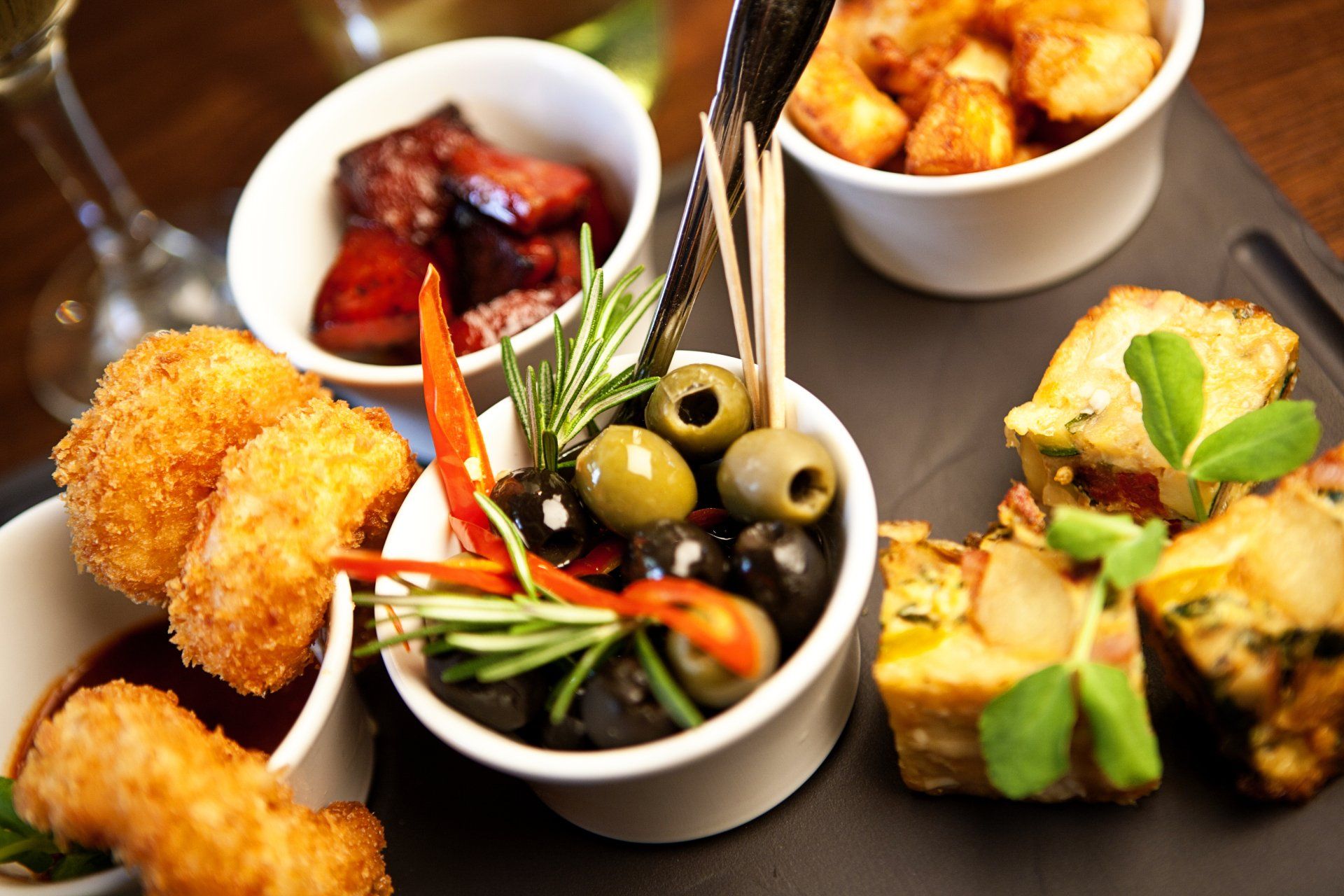 A spread of tapas dishes with olives and croquettes